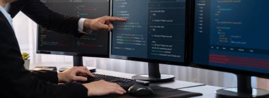 Yazılım geliştirme ekibi ofiste birlikte çalışıyor, bilgisayar ekranında betik görüntülemesi kodluyor. Teknoloji geliştirici şirketinde çalışan programcı ve yazılım mühendisi. Önde.