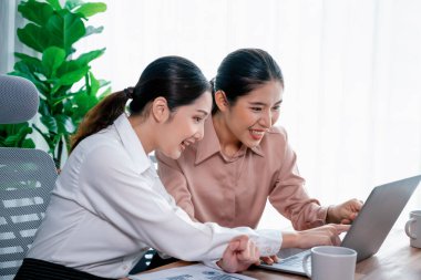 Modern ofis çalışma alanında iş birliği yapan iki genç ofis çalışanı, modern ofis çalışanı olarak profesyonelliklerini sergileyerek, dizüstü bilgisayarda tartışıyorlar ve birlikte çalışıyorlar. Coşkulu.