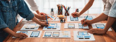 Kağıt kablo arayüzü üzerinde mobil uygulama için UI ve UX tasarımları yapan ön-uç geliştirici ekibin panorama görüntüsü. Kullanıcı dostu UI tasarımı için kullanıcı arayüzü geliştirme ekibi planlama. İnceleyin