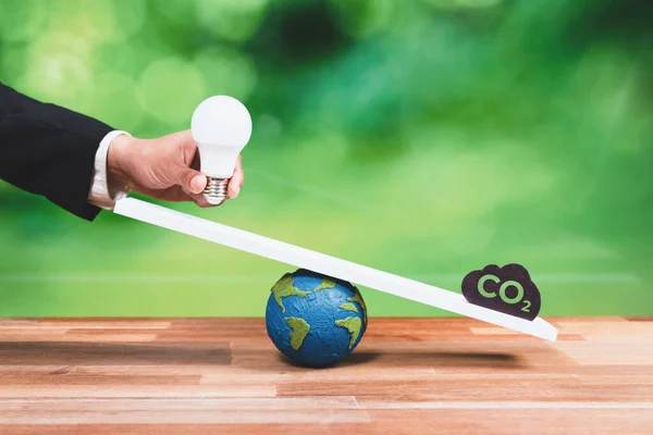 生态平衡的可持续理念相对于二氧化碳符号的重量规模 企业手握灯泡代表着Esg对绿色未来的理念 即企业对生态系统的责任 改变了 — 图库照片