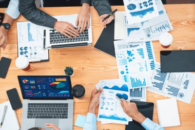 Çok ırklı analist ekibi toplantıdaki finansal verileri analiz etmek için BI Fintech yazılımı kullanıyor. Üst görünüm finans paneli veri ekranında pazarlama göstergesi için analiz edilmiş grafikle birlikte. Uyum