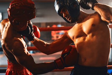 Kasklı iki atletik ve kaslı vücut boksörü ya da boks baş muhafızı vahşi bir boks maçında karşı karşıya. Boks dövüşçüsü boks ringinde dövüşüyor. Impetus