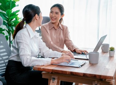 Modern ofis çalışma alanında iş birliği yapan iki genç ofis çalışanı, modern ofis çalışanı olarak profesyonelliklerini sergileyerek, dizüstü bilgisayarda tartışıyorlar ve birlikte çalışıyorlar. Coşkulu.