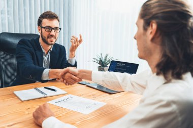 Başarılı bir toplantıdan ya da iş görüşmesinden sonra iki mutlu iş adamı, özgeçmiş belgelerini teslim ederken el sıkışıyor. İnsan Kaynakları müdürü, yeni çalışanı tebrik etmek için iş başvurusunda bulunan kişiye elini uzatıyor. Varlık