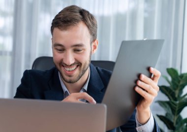 İşadamı ofis masasından sanal ofis toplantısı düzenliyor ve uzaktan çalışanlarla uzak iletişim kurmak için dizüstü bilgisayardaki Webinar uygulamasını kullanarak çevrimiçi video konferansını tartışıyor. Varlık