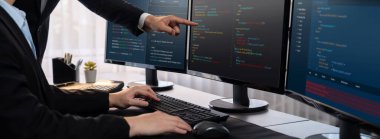 Yazılım geliştirme ekibi ofiste birlikte çalışıyor, bilgisayar ekranında betik görüntülemesi kodluyor. Teknoloji geliştirici şirketinde çalışan programcı ve yazılım mühendisi. Önde.