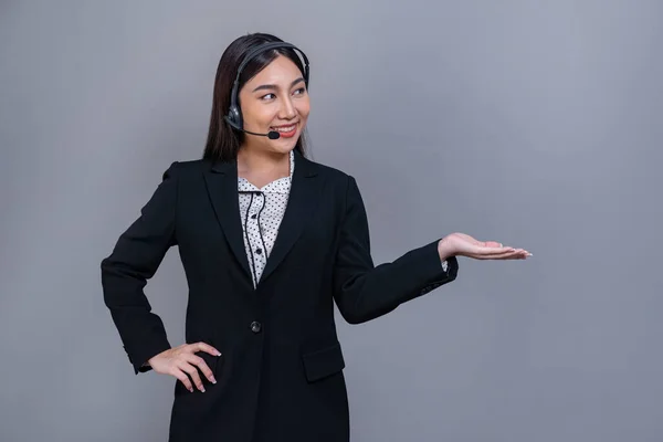 ヘッドセットを着用した女性コールセンター運営者や 製品広告や人事採用のためのハンドジェスチャーを独立した背景で自信を持って立つ正式なスーツ ジュビラント — ストック写真