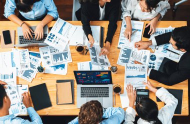 Panorama üst düzey iş analist grubu toplantı masasındaki finansal veri raporunu analiz ediyor. İş zekası analizine göre çizelge ve grafik paneli. Çok titiz.