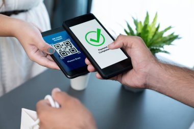 Parasız ödeme taraması için QR kodu ekranda görüntülendi. Kapalı eller, mobil uygulamadan elektronik işlem yoluyla para aktarmak için akıllı telefonu tutuyor. Hızlı ödeme için barkod teknolojisi. Coşkulu
