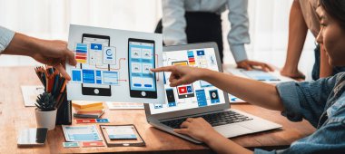 Kağıt kablo arayüzü üzerinde mobil uygulama için UI ve UX tasarımları yapan ön-uç geliştirici ekibin panorama görüntüsü. Kullanıcı dostu UI tasarımı için kullanıcı arayüzü geliştirme ekibi planlama. İnceleyin