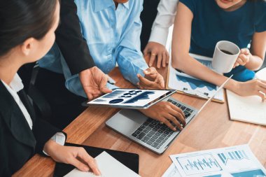 Çok ırklı analist ekibi toplantı masasındaki finansal verileri analiz etmek için BI Fintech yazılımı kullanıyor. Finansal konsol veri ekranında pazarlama göstergesi için analiz edilmiş grafikle birlikte. Uyum