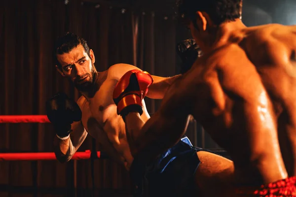 アジアと白人ムエタイのボクサーは激しいボクシング試合でキック攻撃を放つ 力強い筋肉質のボクサーがパンチとキックストライクを容赦ない戦闘力で交換 インペトゥス — ストック写真
