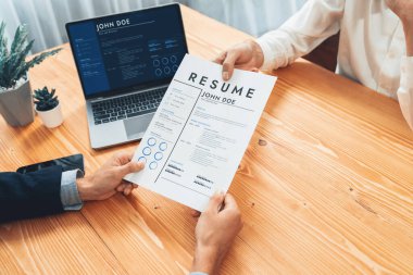 Aday özgeçmişini ya da CV 'yi şirket toplantı odasında mülakata veriyor. İş başvurusunda bulunan kişi, bilgisayar ekranında dijital özgeçmişiyle HR yöneticisine vasıflarını ve iş deneyimlerini göstermiş. Varlık