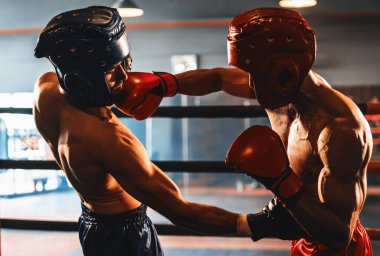 Kasklı iki atletik ve kaslı vücut boksörü ya da boks baş muhafızı vahşi bir boks maçında karşı karşıya. Boks dövüşçüsü boks ringinde dövüşüyor. Impetus