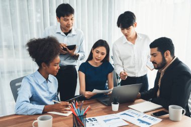 Çok ırklı analist ekibi toplantı masasındaki mali raporu analiz etmek için BI gösterge tablosunu kullanıyor. Çeşitli iş adamlarından oluşan bir grup, FIntech 'in veri analizini başarılı iş pazarlaması için kullanır. Uyum