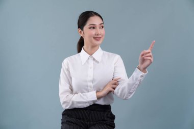 Gülümseyen yüzlü Asyalı kadın çağrı merkezi operatörü, resmi bir takım elbise giyip, özelleştirilebilir izole bir arka planda ürünü işaret eden kulaklık takarak iş fırsatı sunuyor. Coşkulu.