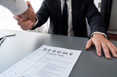 İş yerinde tokalaşmada başarılı bir iş görüşmesi. Nitelikler ve mevki için başvuru hakkında olumlu tartışmalar. Aday ve mülakat arasında iş bulma kavramı. Coşkulu