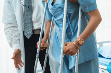 Doktor hastanede koltuk değnekli hastayla ilgileniyor. Fizyoterapist ve bacak yaralanması konsepti. Jivy