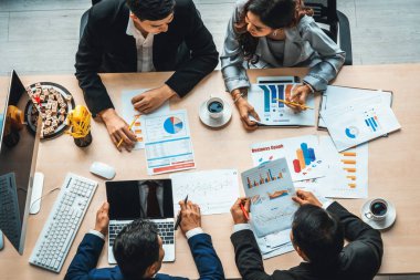 İş adamları grup toplantısı ofiste yukarıdan çekildi. İş kadınları, iş adamları ve ofis çalışanları toplantı masasında proje planlama belgeleriyle takım konferansında çalışıyorlar. Jivy