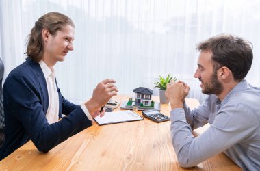 Müşteri ve emlakçı kredi sözleşmesini gözden geçirir, terimleri, faiz oranlarını ve mülkiyet haklarını tartışır. Yasal belgeleri analiz et ve karar vermeden önce anlaşmayı iyice oku. Varlık