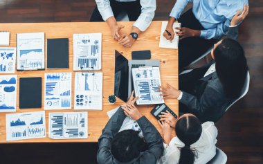 Panorama üst görüşlü çok ırklı analist ekibi, stratejik karar için finansal verileri analiz etmek amacıyla dizüstü bilgisayarda BI gösterge panelini kullanıyor. Fintech pazarlama göstergelerini analiz ediyor. Uyum