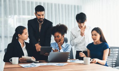 Çok ırklı analist ekibi toplantı masasındaki mali raporu analiz etmek için BI gösterge tablosunu kullanıyor. Çeşitli iş adamlarından oluşan bir grup, FIntech 'in veri analizini başarılı iş pazarlaması için kullanır. Uyum