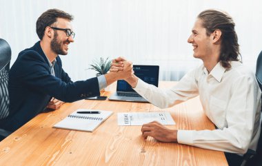 Başarılı bir toplantıdan ya da iş görüşmesinden sonra iki mutlu iş adamı, özgeçmiş belgelerini teslim ederken el sıkışıyor. İnsan Kaynakları müdürü, yeni çalışanı tebrik etmek için iş başvurusunda bulunan kişiye elini uzatıyor. Varlık