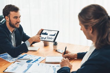 Ofisteki analist ekibi, iş performansını artırmak için tablet ekranında grafik ve grafik olan BI panelini kullanarak çalışma alanındaki pazarlama stratejisi için finansal veri analizi yapmakla meşgul. Varlık