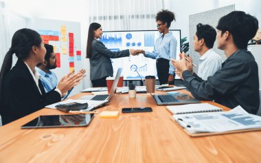 Çeşitli iş arkadaşları bunu şirket işyerinde el sıkışma ve takım çalışmasıyla kutluyor. Başarılı bir toplantıdan sonra el sıkışmayla ya da veri analizi üzerine iş sunumuyla birleşen mutlu iş adamları. Uyum