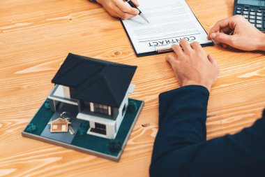 Müşteri ve emlakçı kredi sözleşmesini gözden geçirir, terimleri, faiz oranlarını ve mülkiyet haklarını tartışır. Yasal belgeleri analiz et ve karar vermeden önce anlaşmayı iyice oku. Varlık