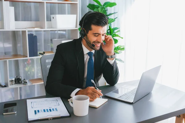 男性呼叫中心操作员或电报局代表穿着耳机坐在办公室桌旁 与提供客户服务支持或销售的客户进行对话 充满热情 — 图库照片