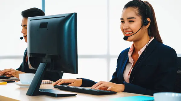 stock image Business people wearing headset working in office to support remote customer or colleague. Call center, telemarketing, customer support agent provide service on telephone video conference call. Jivy