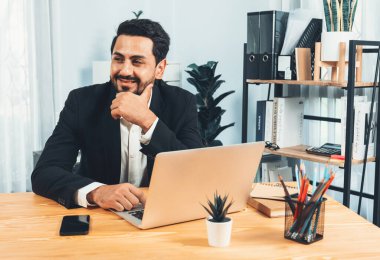 Modern ofis masasındaki modern profesyonel iş adamı çalışmak ve notlar yazmak için dizüstü bilgisayar kullanıyor. Ofisinde bilgisayar defteri üzerinde çalışan çalışkan bir ofis çalışanı. coşkulu