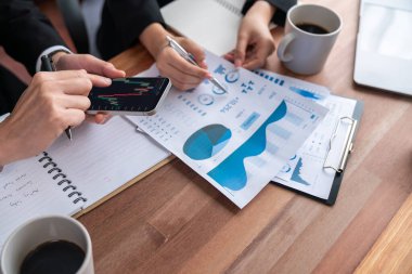 Risk yönetimi ya da finansal ekip, akıllı telefondan hisse senedi grafiklerini izlerken müşteri portföyü üzerinde çalışır ve analiz eder. Ofisinde veri analizi olan hisse senedi yatırım şirketi. Sevinçli.