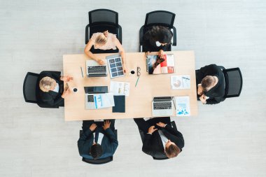 İş adamları grup toplantısı ofiste yukarıdan çekildi. İş kadınları, iş adamları ve ofis çalışanları toplantı masasında proje planlama belgeleriyle takım konferansında çalışıyorlar. Jivy