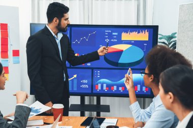Pazarlama stratejisi için modern toplantıda veri analizi paneli ekranında sunan bir işadamı. Bir grup iş adamıyla konferans odasında iş sunumu. Uyum