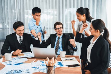 Kutlama jesti ve başarılı takım çalışması yapan bir grup mutlu iş adamı. Çeşitli yarış bürosu çalışanları şirket ofisinde pazarlama planlamasında ilerleme kaydettikten sonra kutlama yapıyorlar. Çok titiz.