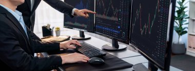 Bir grup tüccar ofis masasında tartışıyor, borsayı işyerinde monitörden izliyorlar. İşadamı ve borsacı borsa şirketinde hisse senedi grafiğini birlikte analiz ediyorlar. Önde.