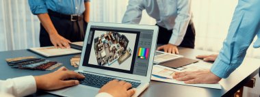 Masadaki bir grup iç mimar takımı dizüstü bilgisayarında mimari yazılım bulunan çeşitli ruh hali tahtası örneklerini seçiyor. Modern yenileme ve iç malzeme seçimi konsepti. İçgörü