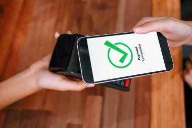 QR kodu parasız ödeme taraması için ekranda gösterilir. Kapalı eller, mobil uygulamadan elektronik işlem yoluyla para aktarmak için akıllı telefonu tutuyor. Hızlı ödeme için barkod teknolojisi. Coşkulu.