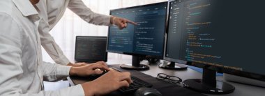 Yazılım geliştirme ekibi ofiste birlikte çalışıyor, bilgisayar ekranında betik görüntülemesi kodluyor. Teknoloji geliştirici şirketinde çalışan programcı ve yazılım mühendisi. Önde.