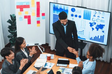 Çeşitli iş arkadaşları bunu şirket işyerinde el sıkışma ve takım çalışmasıyla kutluyor. Başarılı bir toplantıdan sonra el sıkışmayla ya da veri analizi üzerine iş sunumuyla birleşen mutlu iş adamları. Uyum