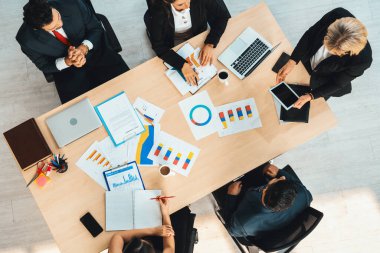 İş adamları grup toplantısı ofiste yukarıdan çekildi. İş kadınları, iş adamları ve ofis çalışanları toplantı masasında proje planlama belgeleriyle takım konferansında çalışıyorlar. Jivy