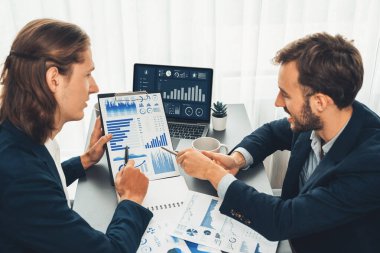 Ofisteki analist ekibi, iş performansını artırmak için bilgisayarında grafik ve çizelge olan BI gösterge panelini kullanarak çalışma alanındaki pazarlama stratejisi için finansal veri analizi yapmakla meşgul. Varlık