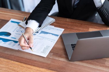 Ofis masasında dizüstü bilgisayarda çalışan bir iş adamı. Akıllı yönetici finansal iş verilerini araştırıyor ya da bilgisayarla stratejik iş pazarlaması planlıyor. Sevinçli.