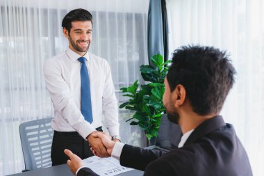 İş yerinde tokalaşmada başarılı bir iş görüşmesi. Nitelikler ve mevki için başvuru hakkında olumlu tartışmalar. Aday ve mülakat arasında iş bulma kavramı. Coşkulu