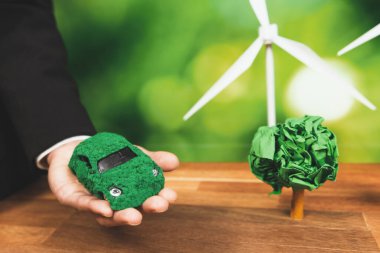 Ofiste yeşil eko araba modelini tutan bir iş adamı. Çevre dostu taşımacılık için kullanılan elektrikli bir araç. CO2 emisyonu sıfır olan bir şirket. Değiştir