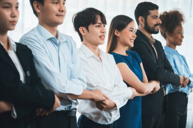 Mutlu ve gülümseyen çok ırklı ofis çalışanı, sinerjiyi ve ticari başarı için işbirliğini destekleyen bir kuyrukta el ele tutuşuyor. Modern işyerinde çeşitli profesyonel ofis çalışanları arasında bağ var. Uyum