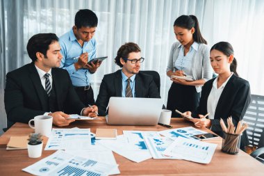 Ofis masasındaki finansal veri raporlarını analiz eden çeşitli bir grup iş analisti. Stratejik pazarlama planlaması için iş istihbarat analizine göre grafikler ve grafikler.