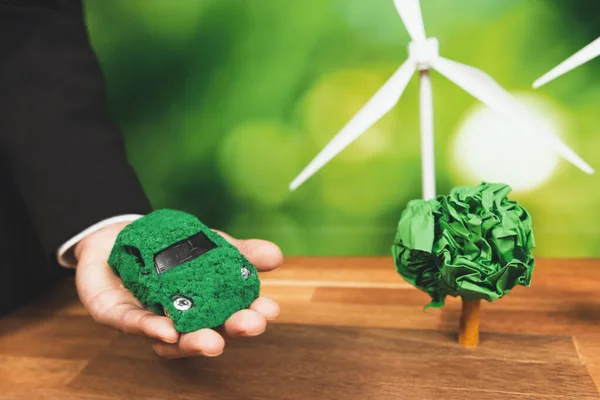 在办公室里持绿色生态车模型的商人 环保型企业使用电动汽车进行环保型交通 公司对二氧化碳零排放负责 改变了 — 图库照片